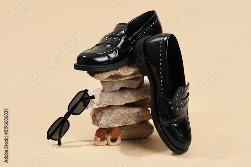 Fashion trends and luxury style, black studded loafers with sunglasses and earrings on stacked stones for modern retail and editorial photography