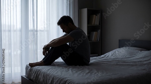 Stressed Man Sitting Alone in Bedroom Representing Anxiety Overthinking Emotional Exhaustion and Mental Health Concerns