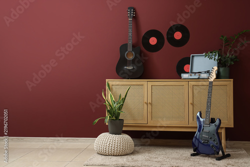 Interior of room with commode, guitars and vinyl disks