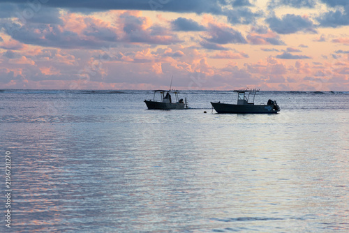Принти на полотні Fishing boats resting on calm ocean at sunset