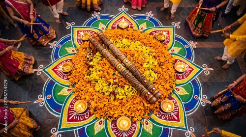 Dandiya raas dance performance with decorated sticks and floral rangoli