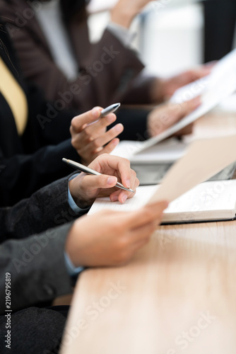 Close Up Business Hands Holding Pens and Paper in Office Meeting