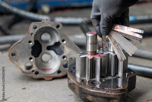 Konstfotografi Mechanic measures hydraulic gear pump clearance using steel feeler gauge in repair workshop