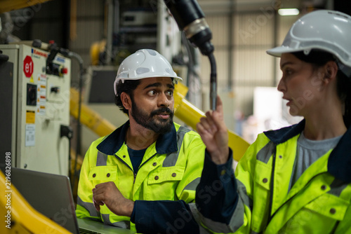 Engineers discussing robotics automation in a factory