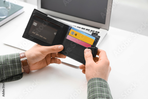 Male hands with wallet and credit cards at table, closeup