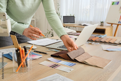 Female interior designer working with fabric samples at table in office