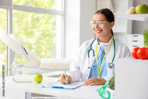 Female nutritionist working on meal plan at table in office