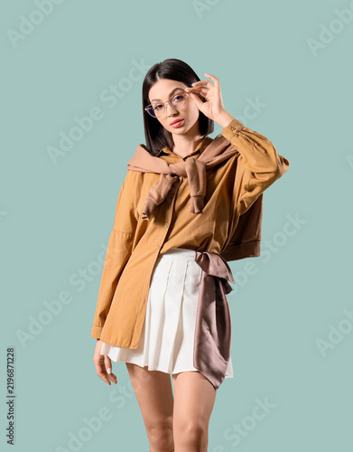 Beautiful fashionable young woman in elegant beige outfit with eyeglasses on ...
