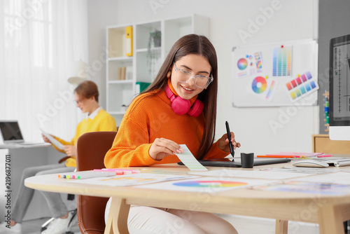 Female graphic designer with tablet working at table in office