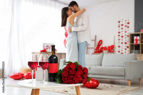 Glasses of wine with roses on coffee table for Valentines Day celebration, cl...