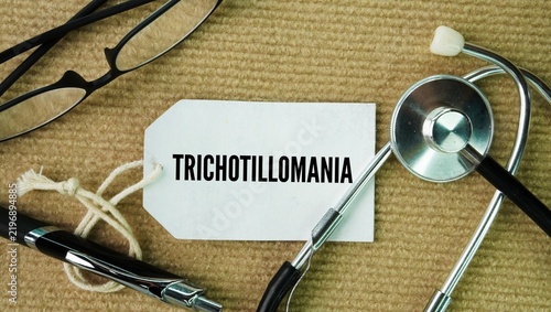 Картината върху платно Stethoscope, glasses and a paper tag with the word Trichotillomania are hair pulling disorder