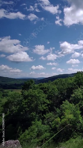Scenic Green Hills and Mountain Landscape Under Fluffy White Clouds