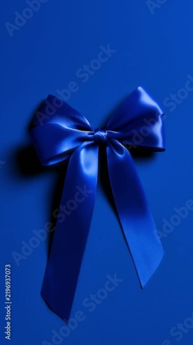 Blue satin ribbon bow moving animated on blue gift box background
