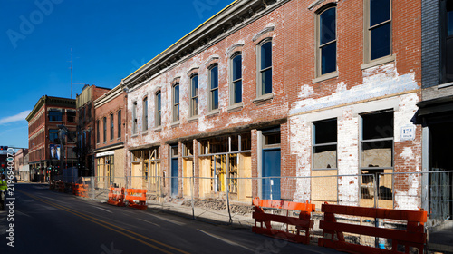 professional documentary architectural photography of a generic older commercial building undergoing renovation, original brick exterior partially restored beside a newly finished section, 