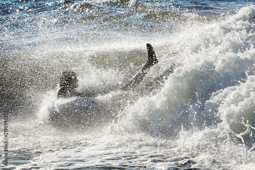Canvas Print Man in wetsuit falling while surfing wave