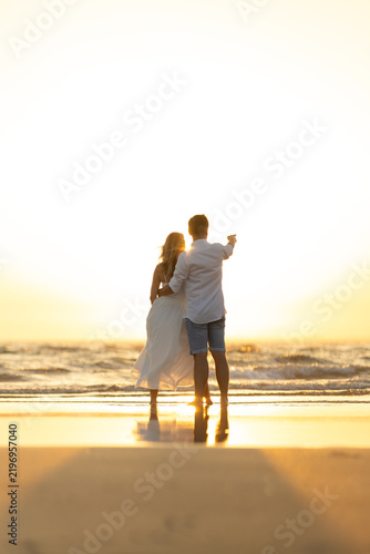 Fotografía Couple walks on the beach at sunset enjoying the warmth and beauty of the evenin