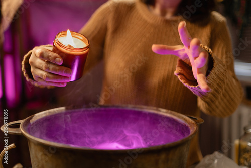 Quadro su tela realistic witch with candle over cauldron brewing potion casting spells
