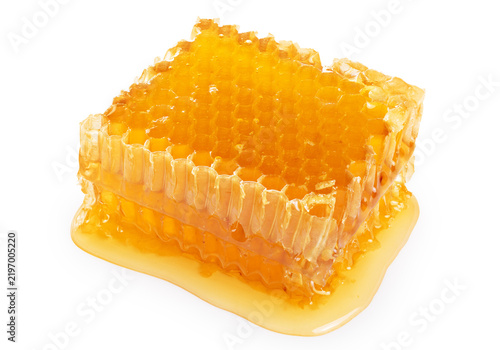 Piece of wax honeycomb filled with honey, isolated on white background.