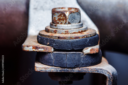 Rusted metal bolt securing cracked rubber bushings