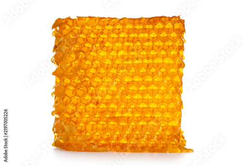 Piece of wax honeycomb filled with honey, isolated on white background.