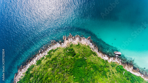 Картината върху платно High angle drone view of a green rocky island cape surrounded by clear turquoise ocean water