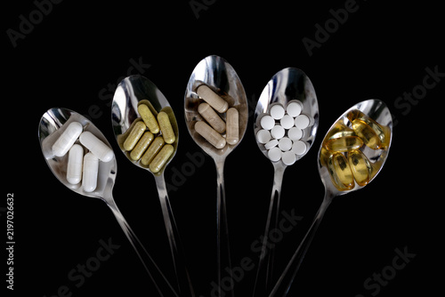 Top view of wellness supplements and daily dose of vitamins on a spoon