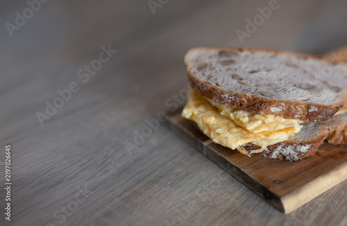 Rustic walnut bread with fluffy omelet served on a wooden board
