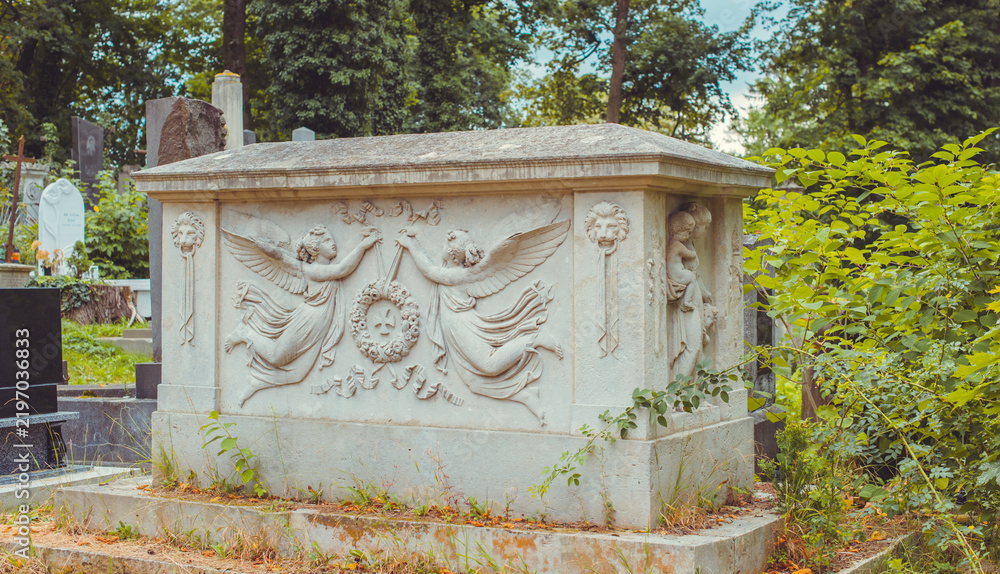 Fototapeta premium Ancient European cemetery with stone angels and historic tombstones
