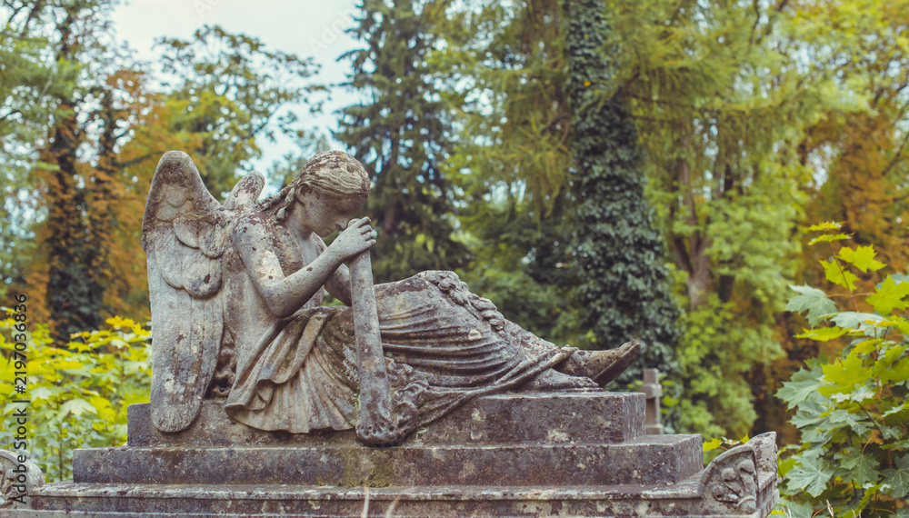 Fototapeta premium Ancient European cemetery with stone angels and historic tombstones