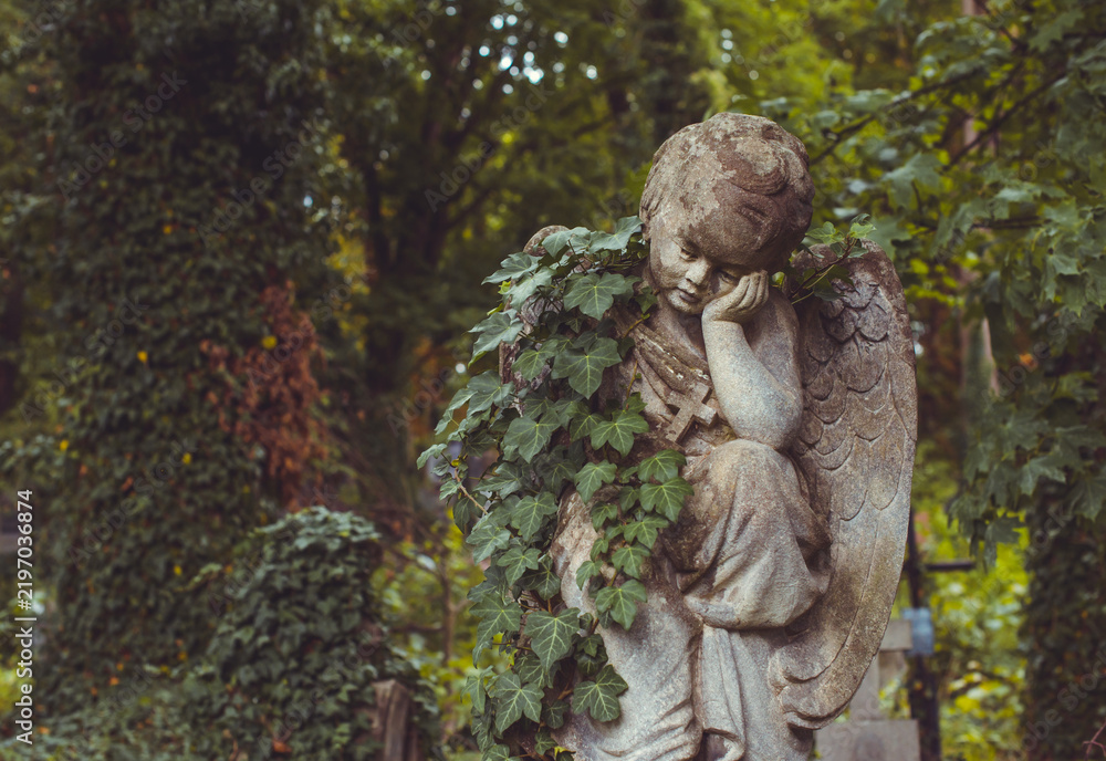 Fototapeta premium Ancient European cemetery with stone angels and historic tombstones