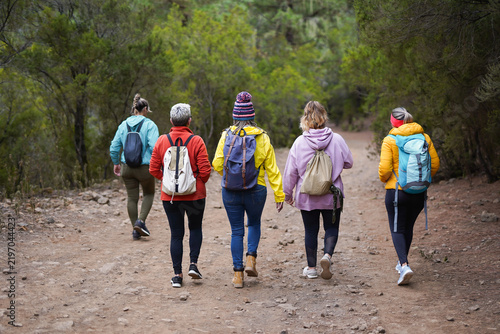 Multi generational women having fun during trekking day outdoor - Female group hiking in the mountain during autumn season - Diverse people and active lifestyle concept