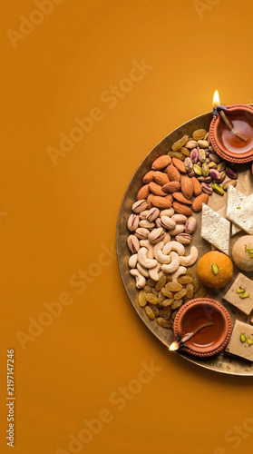 Diwali food banner with premium dry fruits, traditional sweets and glowing diyas.