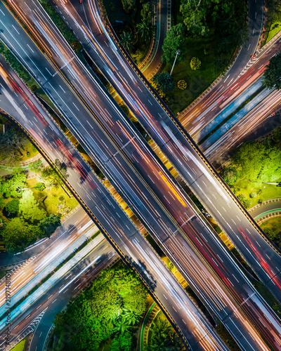 Aerial view of the Semanggi Interchange at night with long exposure light trails from traffic flowing through the highway junction surrounded by urban greenery Jakarta, Jakarta, Indonesia.