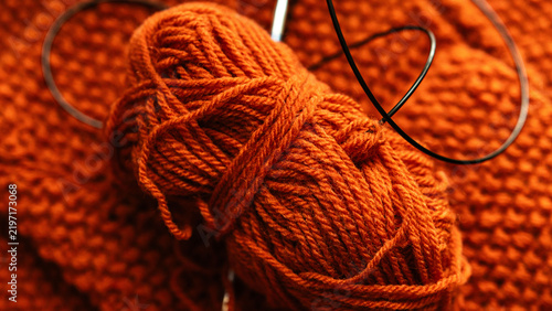 Close Up of Orange Wool Yarn Ball with Knitting Needle Cable