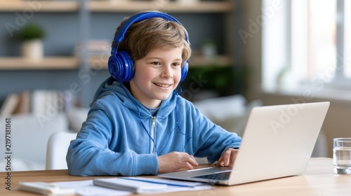 Smiling Boy in Headphones Studying Online with Laptop at Home