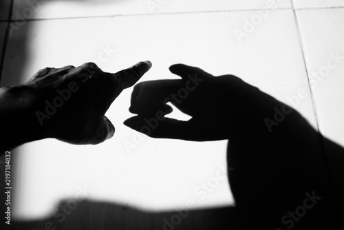 Close up black and white of hand with shadow pointing gesture on the dirty floor