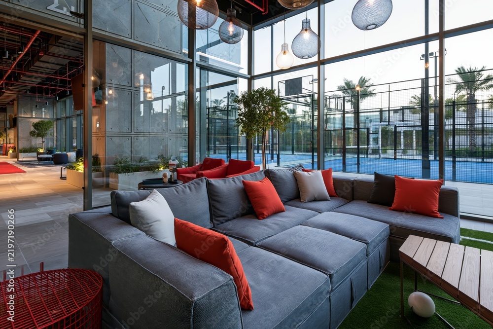 Fototapeta premium Modern padel club lounge overlooking courts through glass walls, luxury sports lifestyle environment, contemporary interior and fitness design