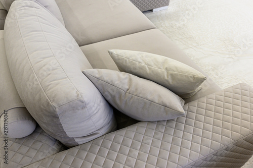 Fotografía Plush beige sofa with quilted diamond pattern, oversized cushions, soft throw pi