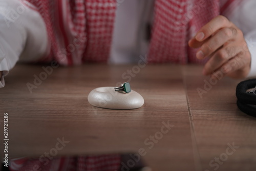 Fotografie Traditional Middle Eastern man in keffiyeh displaying a ring and prayer beads
