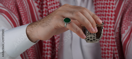 Foto Traditional Middle Eastern man in keffiyeh displaying a ring and prayer beads