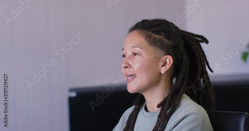 Adult nonbinary African replying to offcamera speaker leaning gesturing pen at office, copy space