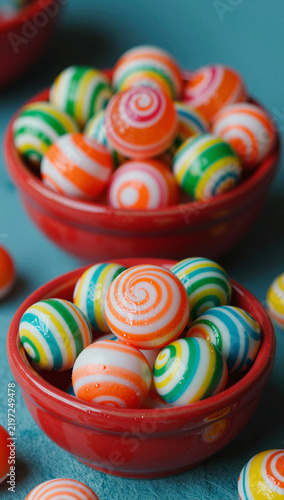 Bright red bowls filled with colorful, swirled candies.