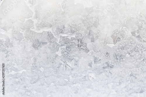 white winter background, frosty patterns on glass, abstract backdrop of ice and snow crystals in a blur