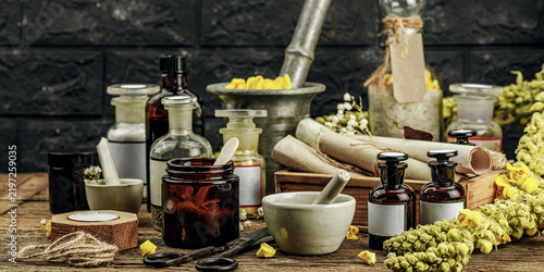 Rustic apothecary scene with Verbascum flowers, herbal jars, vintage tools and mortar