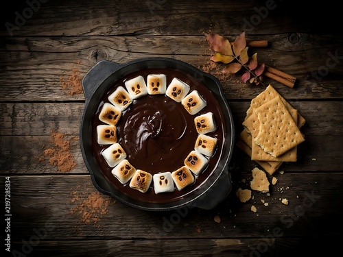 Delicious Halloween themed smores dip with ghost marshmallows in a cast iron skillet
