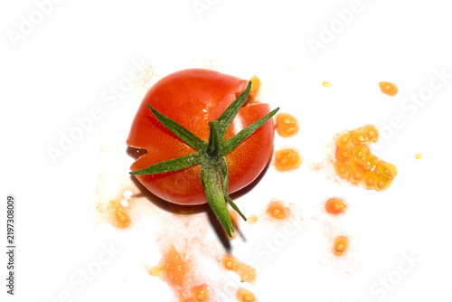 A squashed splattered and crushed broken fresh tomato with seeds