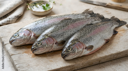 Three raw fresh trout fish on a wooden kitchen board illustration