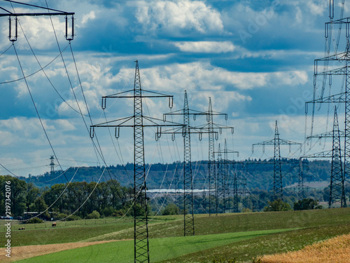 Strommasten einer Überlandleitung unter bewölktem Himmel