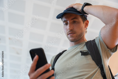 Foto Man experiencing travel stress checking smartphone