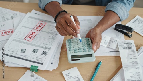 Person calculating bills with past due notice